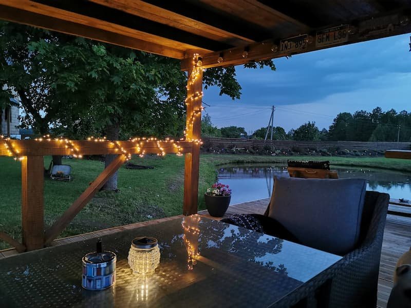 Vakarinis apšvietimas Jiesios sodybos pavėsinėje prie tvenkinio – romantiška aplinka šventėms